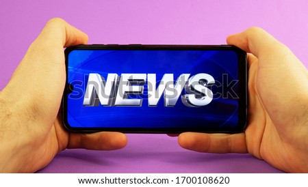 in men's hands phone with news on a purple background