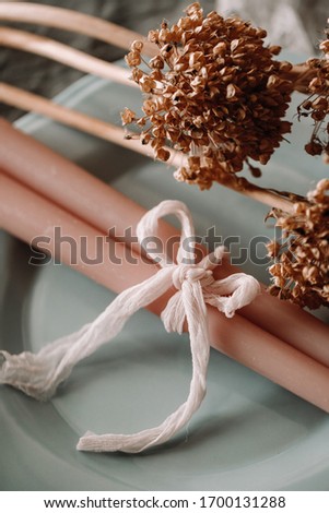 Focus view of cute and elegant cloth fabric use to tie candle. Wedding decoration on the plate. Fancy golden flower on the side perfect for props photography.