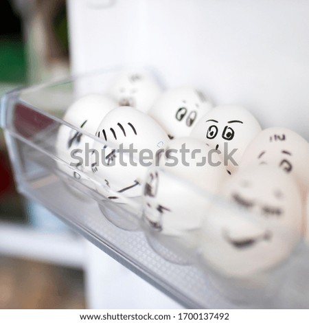 concept social networks communication and emotions - eggs wink in the fridge. Copy space