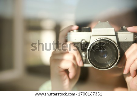 A woman takes photos with a retro camera