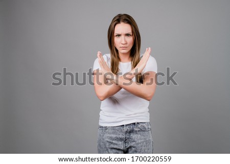 angry woman saying no with hands crossed isolated on grey background