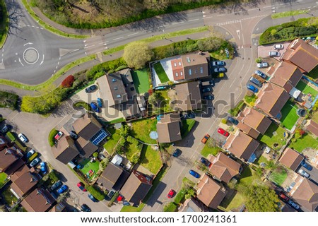 Houses on a housing estate in Hampshire, United Kingdom with deserted streets during lockdown quarantine for Coranavirus Covid 19. All cars are parked and no cars are moving. On a sunny day Royalty-Free Stock Photo #1700241361
