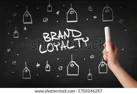 Hand drawing BRAND LOYALTY inscription with white chalk on blackboard, online shopping concept