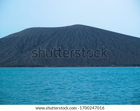 Small Eruption and Dark gray volcanic products of Anak Krakatau mountain seen from Sunda Strait on August 2019. Indonesia