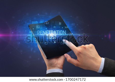 Businessman holding a foldable smartphone with PENETRATION TEST inscription, cyber security concept Royalty-Free Stock Photo #1700247172