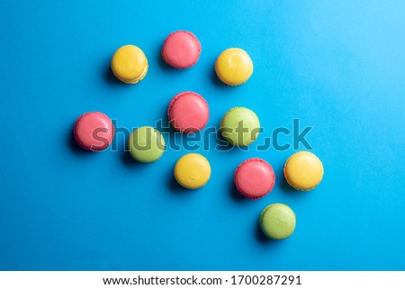 Cake macaron on blue background from above. Colorful cookies on dessert, flat lay