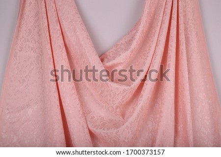 Delicate pink fabric with lace lies on the table