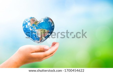 Earth Day concept:  hand hold Earth in Heart shape on Natural background, Elements of this image furnished by NASA