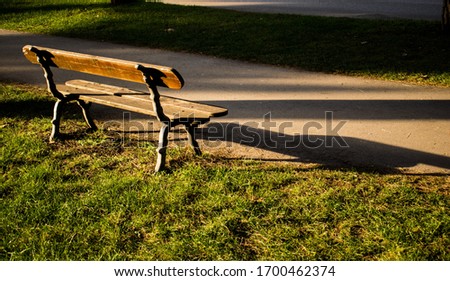 An empty wooden bench in a park during daytime