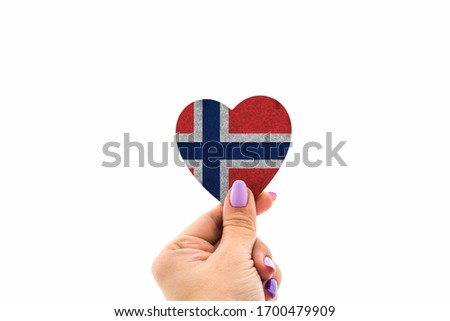 Heart sign Norway flag in woman's hand against the sky. 
