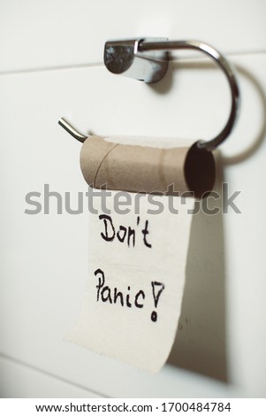 A finished toilet paper roll with a Don't panic sign - Panic because of the coronavirus concept
