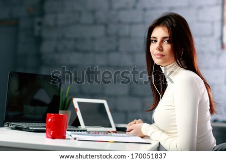 Young businesswoman sitting at the table on her workplace in office