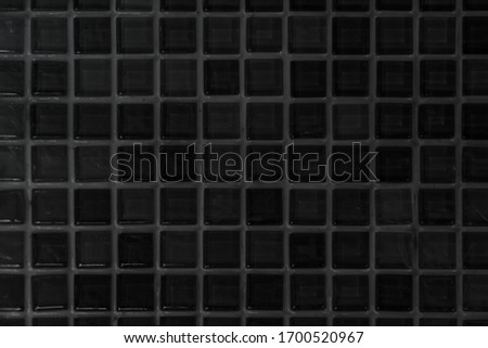 Black tile wall high resolution real photo or brick seamless  pattern and texture interior room background. Dark grid tiles wall texture for the decoration of the bedroom, Home or office backdrop.