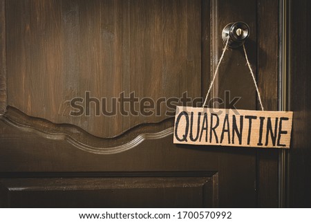 Quarantine plate on a wooden door. The inscription quarantine. Quarantine. Insulation. Self isolation.