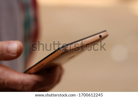 A person holds the phone with one hand and writes