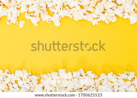 Popcorn on yellow background. Movie or TV background, border, frame. Top view Copy space