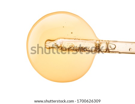 Liquid yellow-orange retinol or vitamin c gel or serum on a screen of microscope white isolated background Royalty-Free Stock Photo #1700626309