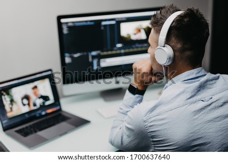 Young Male Editor Editing Video On Computer At Workplace