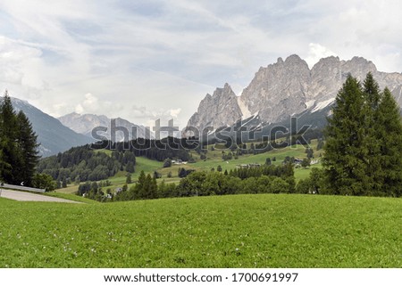 Dolomites alpine mountains landscape. Green meadow on front side of picture and mountains peaks on the background. Dolomity, Italy.Famous landmark.Travelling concept background.
