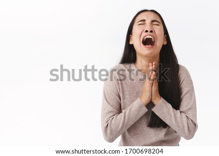 Girl crying her heart out begging for mercy or apology, telling she sorry, holding hands in pray, having mental breakdown, dont know what do, supplicating, raising head up and asking god help Royalty-Free Stock Photo #1700698204