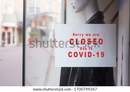 Closeup of information sign on the window of the fashion store front : Sorry we are Closed due to covid-19