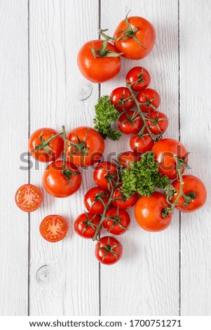 Composition of red tomatoes with green parsley on white wooden surface as background. Blank for menu at restaurant. Concept of fresh ingredients picture