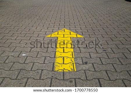Simple straightforward solution concept: Yellow arrow an paving blocks showing direction straight ahead Royalty-Free Stock Photo #1700778550