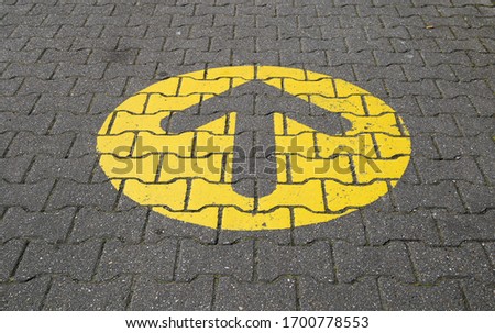 Simple straightforward solution concept: Yellow arrow in circle on paving blocks showing direction straight ahead Royalty-Free Stock Photo #1700778553