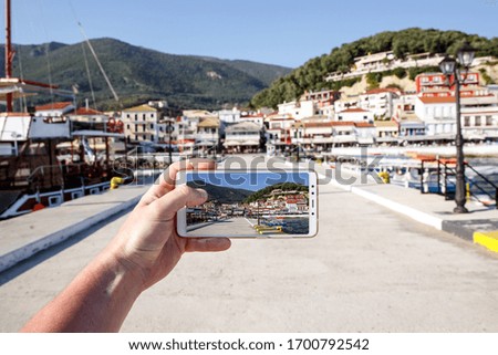 Using your smartphone as a mobile camera while traveling. Tourist city port on screen