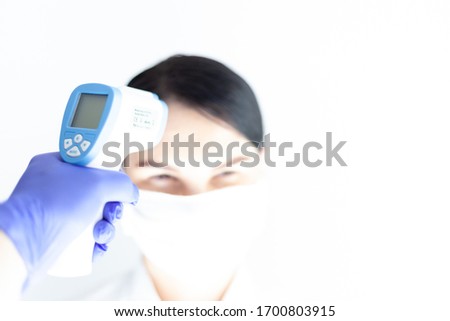 Doctor check woman body temperature using infrared thermometer for virus symptom