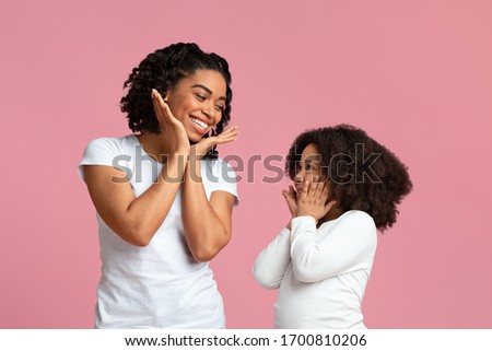 Sweet Little Black Girl Enjoying Spending Time With Mom, Repeating Her Gestures And Laughing Together, Isolated On pink Background With Copy Space