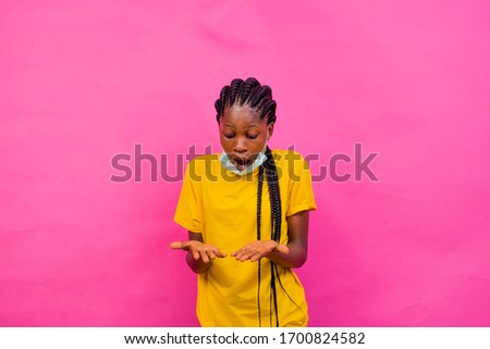 portrait picture of a beautiful african girl looking her hands with a surprise on her face