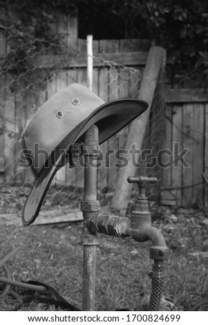 A tap utilized as a storage place for a hat.