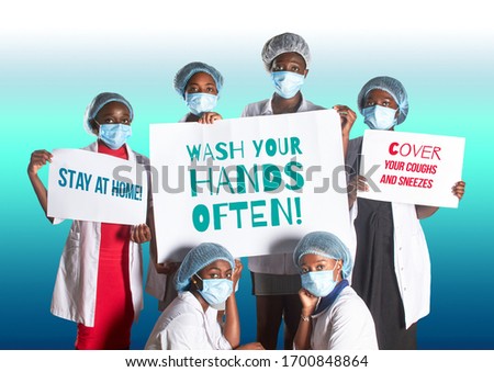 Group of African women nurses activists in face mask with hand sign placard with caption Wash your hands often. Group of medics with message to public, awareness campaign for covid-19 illness.