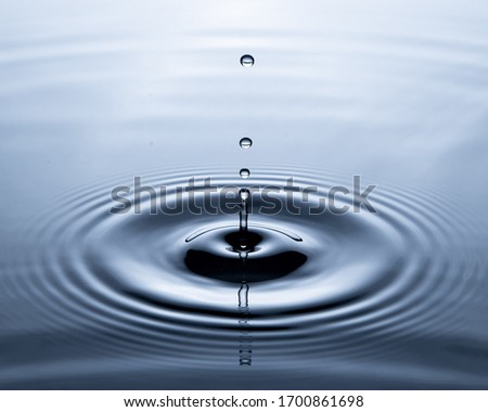 Water drop on water surface Royalty-Free Stock Photo #1700861698