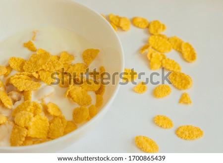 Cornflakes with milk in a deep white bowl. White background. Delicious and healthy Breakfast.