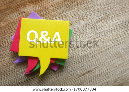 Top view stack of colorful speech bubbles with the top written with Q&A or questions and answers on wooden background. Royalty-Free Stock Photo #1700877304