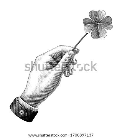 Hand hold clover leaf drawing vintage style black and white clipart isolated on white background