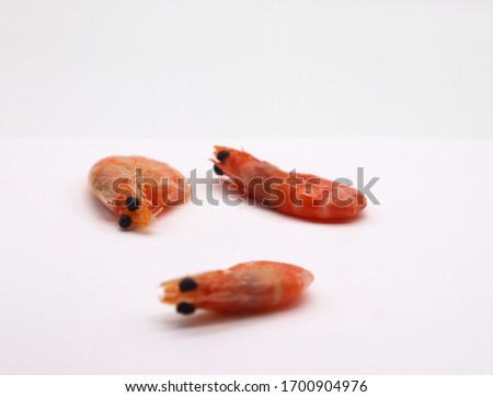 Three king prawns isolated on the light background, front view, close-up. With a place for text