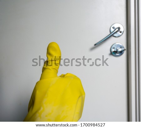 Male hand showing thumbs up sign after cleaning door to prevent spread of covid-19 corona virus,Sweden