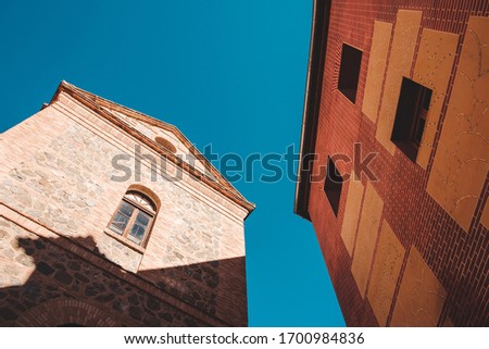 A low angle shot of architectural design of a building with a clear blue sky in the background