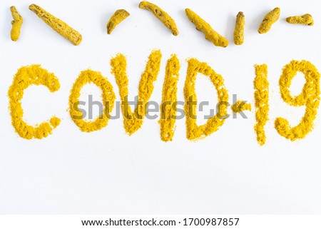 turmeric on a white background is scattered with the word cavid-19 as a natural yellow antiseptic in powder