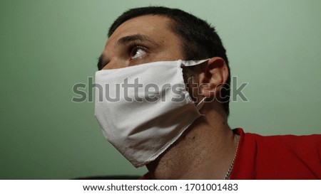 A young man is quarantined at home for a covid-19 face mask