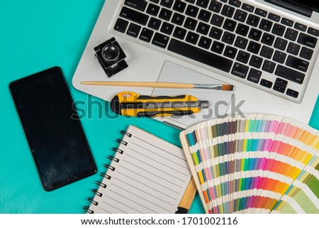 color scale with stylus and magnifying glass on it and a keyboard to form an element of the creative office environment