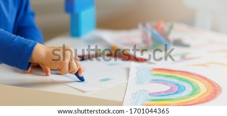 Kids paint. Quarantine fun. Child painting rainbow, sign of hope during coronavirus outbreak. Little boy drawing. School kid doing art homework. Arts and crafts for kids. No face Royalty-Free Stock Photo #1701044365