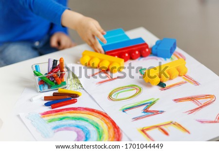 Kids paint. Quarantine fun. Child painting rainbow, sign of hope during coronavirus outbreak.School kid doing art homework. Arts and crafts for kids. Constraction