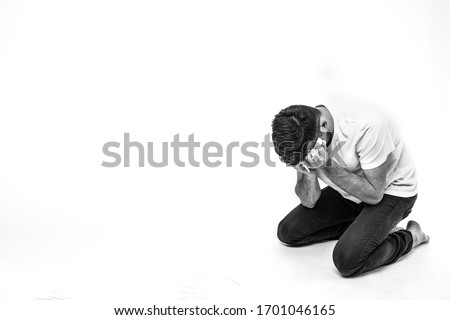 Young man isolated over background. Picture of man in depression and desperate state. Heartbroken breakdown person alone in room or studio. Failrue, sadness or shame stress. Royalty-Free Stock Photo #1701046165