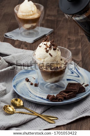 Affogato coffee. Italian dessert ice cream coffee clear glass, chocolate, french press gold spoons on dark wood table Royalty-Free Stock Photo #1701053422