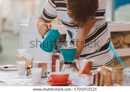 Young adult making coffee in a mug outdoor