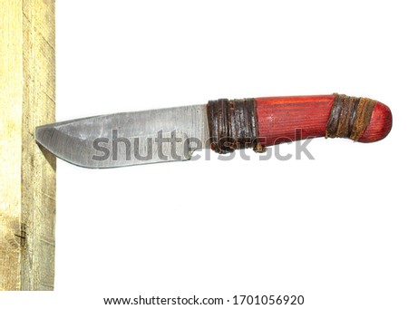side view of Damascus knife stuck in the wooden board